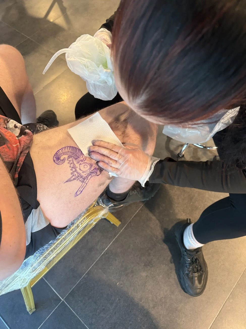 A tutor guiding a student in the Dublin Tattoo College studio